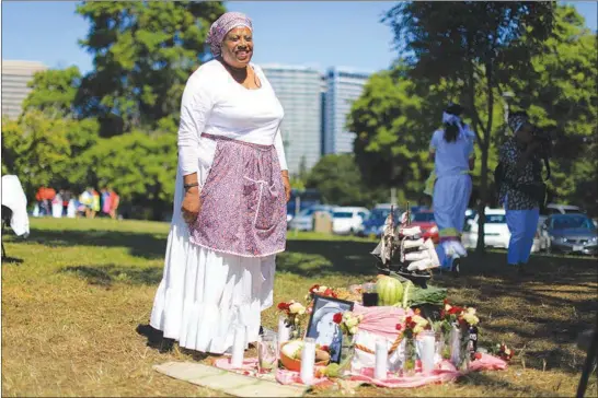  ?? JIM WILSON / THE NEW YORK TIMES ?? Wanda Blake stands beside an altar of symbolic foods during a Juneteenth Ritual of Remembranc­e on June 10 in Oakland, Calif. Juneteenth, which celebrates the abolition of slavery in the United States, is an occasion to gather and eat.