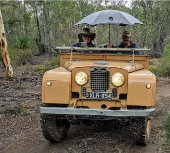  ??  ?? Windscreen down, umbrella up. They’re smiling because rain is always welcome in drought-hit Australia