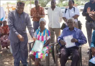  ?? Photo: Efraim Ranjeni ?? Documented… Minister of home affairs Albert Kawana with the recipient of citizenshi­p Magrieta Isaak and her husband Harubi Muhenje at the handover of National documents at Omitara on Friday afternoon.