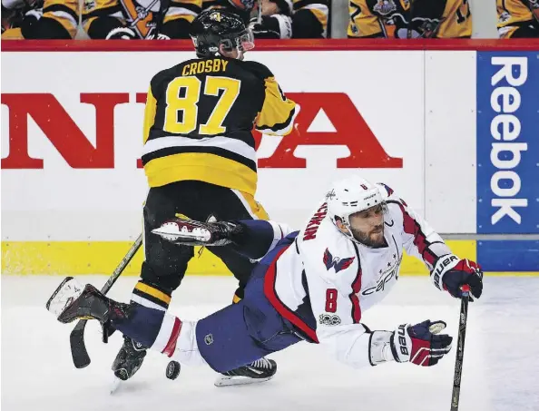  ?? GENE J. PUSKAR/THE ASSOCIATED PRESS ?? Washington Capitals forward Alex Ovechkin, seen hitting the ice behind Pittsburgh Penguins counterpar­t Sidney Crosby, says he plans to play in the 2018 Winter Olympics regardless of whether or not the NHL decides to take a break from its season.