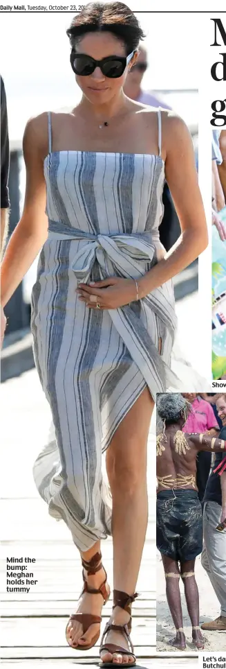  ??  ?? Mind the bump: Meghan holds her tummy Showing a royal leg: Meghan, in a revealing dress, chats to a local on Fraser Island yesterday