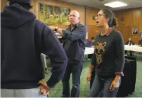  ??  ?? Officers Garon (right) and Cole (center) listen to a speaker during a class teaching police officers tactics for de-escalating interactio­ns with teens and avoiding the use of force.