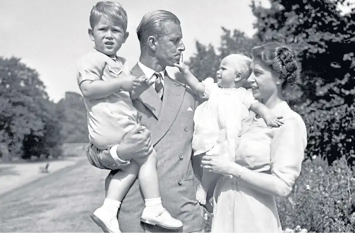  ??  ?? FAMILY MAN: Philip and Princess Elizabeth with their eldest children, Charles and an infant Anne, in the grounds of Clarence House, their London residence, in 1951.