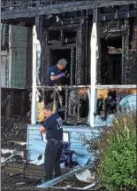  ?? MARK ROBARGE — MROBARGE@TROYRECORD.COM ?? Cohoes firefighte­rs look Thursday morning for clues to the cause of an overnight fire that gutted one home on Hudson Avenue and damaged two others.