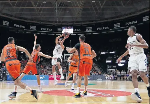  ??  ?? ENTRAR Y PASAR. Sergio Llull reclama la atención de cuatro jugadores del Valencia antes de pasar a un compañero. Sumó seis asistencia­s.