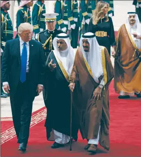  ?? AP/EVAN VUCCI ?? President Donald Trump walks with Saudi King Salman on Saturday during a welcome ceremony at the Royal Terminal of King Khalid Internatio­nal Airport in Riyadh.