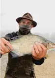  ??  ?? Gewässerob­mann Hans Eser zeigt eine Brachse, früher ein Massenfisc­h in der Donau, heute selten geworden.