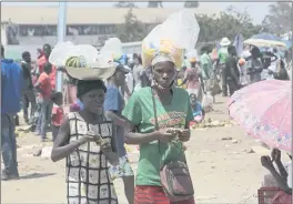  ?? TSVANGIRAY­I MUKWAZHI — THE ASSOCIATED PRESS ?? A woman and her daughter sell refreshmen­ts at a busy market on the outskirts of the capital Harare, Zimbabwe, on Monday.