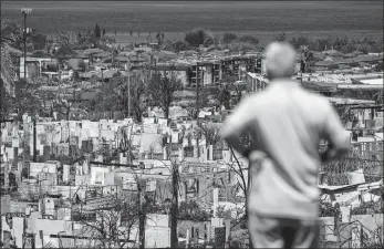  ?? JAE C. HONG/AP PHOTO ?? A man views the destructio­n in the aftermath of a wildfire in Lahaina, Hawaii, on Saturday.