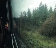  ??  ?? A child looks out the window of a Keewatin Railway train in northweste­rn Manitoba during the nine-hour trip to Mathias Colomb.