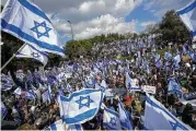  ?? AP ?? Israelis wave national flags during protest against plans by Prime Minister Benjamin Netanyahu’s new government to overhaul the judicial system, outside the Knesset, Israel’s parliament, in Jerusalem, Monday.