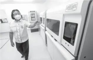  ??  ?? NEW MACHINES –Sta. Ana Hospital Director Dra. Grace Padilla shows the new machines inside the newlyinaug­urated swab testing and molecular laboratory at Sta. Ana Hospital on Tuesday. The second molecular laboratory was donated by the Ayala Group of Companies to the City of Manila. (Jansen Romero)