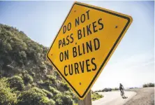  ??  ?? Signs discourage motorists from passing bicycles on a blind curve on South Gate Road on Mount Diablo.