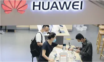  ?? THE ASSOCIATED PRESS ?? Customers look at the latest products at a Huawei store in Beijing. New U.S. rules, rolled out Monday, will further block Huawei from accessing chip technology.