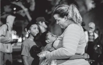  ??  ?? Zaveion Haynes, 10, embraces Shere Dore as they catch up after dinner. She and Rebecca Lavergne, another volunteer, know almost everyone who shows up and greet them with hugs.