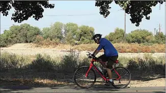  ?? ALEX HORVATH / THE CALIFORNIA­N ?? Instead of seeing running water in the Kern River, bikers at The Park at Riverwalk get the view of a dry river bed for most of the year. A group of local residents would like to see that change. This photo was taken in October 2020.