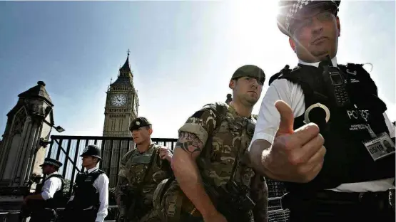  ?? Daniel Leal-Olivas/AFP ?? Policiais e soldados fazem guarda diante do Parlamento britânico e o Big Ben, em Londres; Reino Unido segue em alerta máximo com militares nas ruas