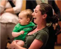  ?? AFP ?? A mother holds her child after racing in the NYC Triathlon’s annual Diaper Derby in New York City. Births in the US have plunged to record lows not seen in decades. —