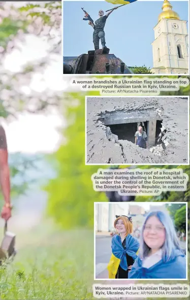  ?? Picture: AP/Natacha Pisarenko Picture: AP Picture: AP/NATACHA PISARENKO ?? A woman brandishes a Ukrainian flag standing on top of a destroyed Russian tank in Kyiv, Ukraine.
A man examines the roof of a hospital damaged during shelling in Donetsk, which is under the control of the Government of the Donetsk People’s Republic, in eastern Ukraine.
Women wrapped in Ukrainian flags smile in Kyiv, Ukraine.