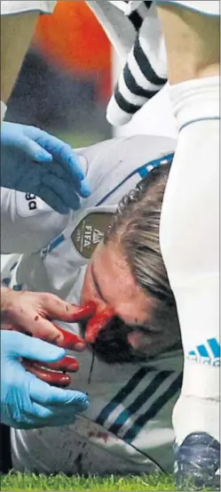  ??  ?? IMPACTANTE. Ramos, sangrando en el césped del Metropolit­ano.