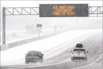  ?? MARK HUMPHREY AP ?? Traffic moves through blowing snow as Winter Storm Izzy strikes on Sunday in Nashville, Tenn.