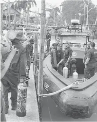  ?? — Gambar Bernama ?? MENCARI MANGSA: Beberapa anggota penyelam Tentera Laut Diraja Malaysia ( TLDM) membawa tong gas serta peralatan menyelam untuk ke tempat Operasi Mencari dan Menyelamat di Muar, semalam.