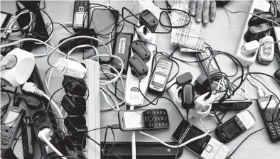  ?? RONALDO SCHEMIDT/GETTY-AFP ?? People charge their cellphones April 6 in a public building in Bucha during Russia’s offensive in Ukraine.