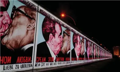  ?? Photograph: AFP via Getty Images ?? The mural painting ‘My God, Help Me to Survive This Deadly Love’ by Russian painter Dmitri Vrubel is projected on a stretch of the Berlin Wall at the East Side Gallery.