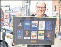  ?? JIM DAY/THE GUARDIAN ?? Local businessma­n Campbell Webster holds up a plaque that recognizes his work on the ECMA board of directors. Webster says the annual awards and music conference has helped East Coast musicians make a decent living.