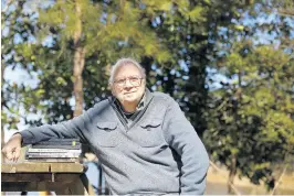  ?? JONATHON GRUENKE/STAFF ?? Author Chris Dickon with a collection of books he wrote.