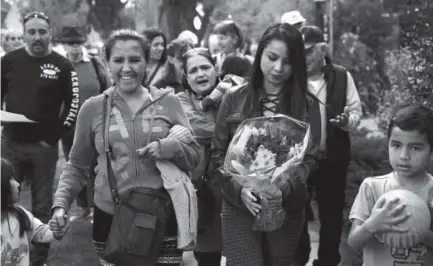  ??  ?? Ingrid Encalada Latorre carries flowers while walking with Jeanette Vizguerra on Saturday after Latorre was granted a temporary stay of deportatio­n. Joe Amon, The Denver Post