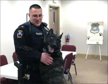  ?? BILL DEBUS — THE NEWS-HERALD ?? Perry Village Police Lt. Michael Collins shares a moment with Zeke, a 2-year-old Dutch shepherd, who will become the Police Department’s next K-9 officer. The pair visited the Perry Village Council meeting on Jan. 10. Zeke will partner with Collins once the dog completes training and is inducted into the department.