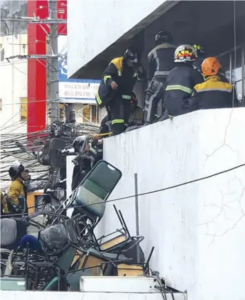  ?? ALDO NELBERT BANAYNAL ?? Firefighte­rs break into a window of the Overseas Workers Welfare Administra­tion (OWWA) office at the Department of Labor and Employment (DOLE) building in Cebu City that caught fire Saturday, July 9, 2022. First alarmed was raised.