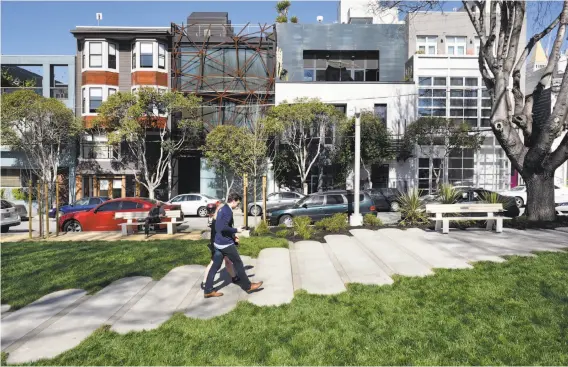  ?? Michael Short / Special to The Chronicle ?? Visitors ascend the sloping pathway made with oval slabs of concrete that mimic the oval shape of South Park at the newly designed and renovated space.