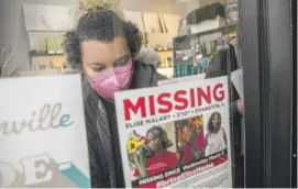  ?? PAT NABONG/ SUN-TIMES ?? Volunteer Coco Fernandez sticks a flyer for missing transgende­r rights activist Elise Malary to a store window along North Clark Street in the Andersonvi­lle neighborho­od on Saturday morning. Police later announced Malary had been found dead.