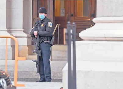  ?? BRAD HORRIGAN/HARTFORD COURANT ?? A Capitol police officer stands in front of the state Capitol in Hartford on Thursday afternoon.