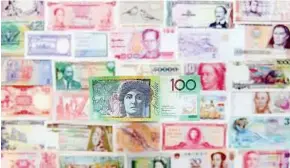  ?? – AFP ?? Cashing in: Asian currencies are likely to rise against the US dollar in the near future, thanks to the region’s superior growth and trade surpluses.