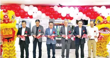  ??  ?? Kim (third from left) and Lim (third from right) with other LG senior managers declaring open the LG Electronic­s’ first brand shop at E Mart at Karamunsin­g Complex yesterday.