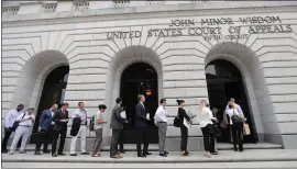  ?? GERALD HERBERT — THE ASSOCIATED PRESS ?? People wait in line to enter the 5th U.S. Circuit Court of Appeals in New Orleans to sit in overflow rooms to hear arguments regarding “Obamacare” on Tuesday. The court ruled Wednesday that the “individual mandate” of former President Barack Obama’s health care law is invalid, but other parts of the law need further review.