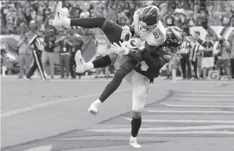  ?? Mark Zaleski / Associated Press ?? Tennessee wide receiver Corey Davis catches the winning TD pass over Philadelph­ia cornerback Avonte Maddox in overtime in Nashville. Davis had nine receptions for 161 yards.