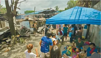  ?? SUN.STAR PHOTO / AMPER CAMPAÑA ?? SHELTER: Families affected by the recent fire in Labangon take shelter at the roadside near the fire scene.