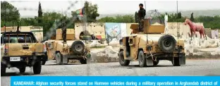  ?? — AFP ?? KANDAHAR: Afghan security forces stand on Humvee vehicles during a military operation in Arghandab district of Kandahar province on Sunday.