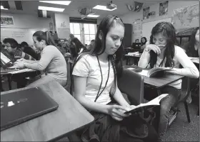  ?? NWA Democrat-Gazette/ANDY SHUPE ?? Katherine Ascencio (center), 17, and Lisset Martinez, 16, both sophomores at Har-Ber High School, read Thursday in the language academy meant for English language learners at the school in Springdale. A new law, Act 991, changes testing and performanc­e...