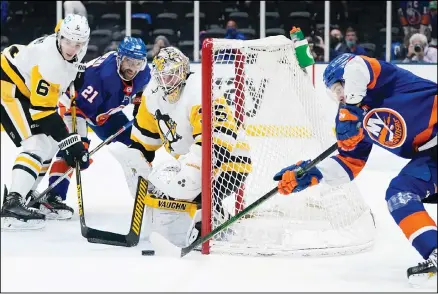 ??  ?? Pittsburgh Penguins goaltender Tristan Jarry (35) stops a shot on goal by New York Islanders’ Mathew Barzal (13) during the second period of Game 4 of an NHL hockey Stanley Cup first-round playoff series, on May 22, in Uniondale, NY. (AP)