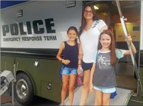  ?? BILL RETTEW JR. – DIGITAL FIRST MEDIA ?? The Abraham sisters, Julia, left, Anna and Abby, check out the equipment at National Night Out in West Chester.