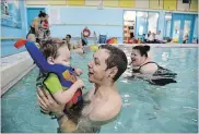  ??  ?? Two-year-old Bennett O'Brien-Underhill lives with severe cerebral palsy and is the most relaxed in the warm pool with his dad, Travis.