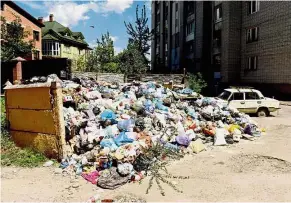  ?? — AFP ?? What a stink: An overflowin­g pile of garbage growing bigger by the day along a back alley in Lviv.