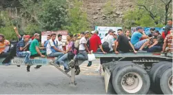  ??  ?? Migrantes hondureños viajaron de aventón en camiones de carga para llegar en caravana a la Ciudad de Guatemala.