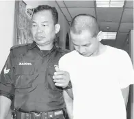  ??  ?? RIZUAN (kanan) diiringi anggota polis, keluar dari kamar mahkamah.