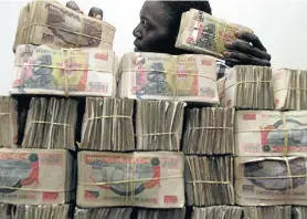  ?? Picture: REUTERS ?? TAKING NOTES: A Zimbabwean man piles up the black market equivalent of US$1 000
